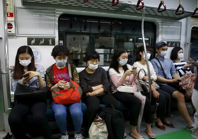 Passengers wearing masks to prevent contracting Middle East Respiratory Syndrome (MERS) sit inside a train in Seoul