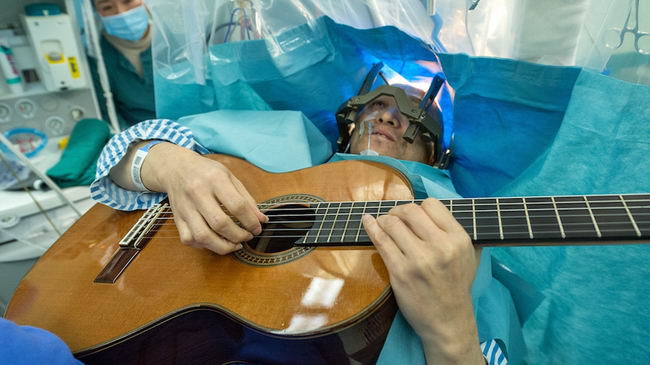 Man plays guitar while having brain surgery